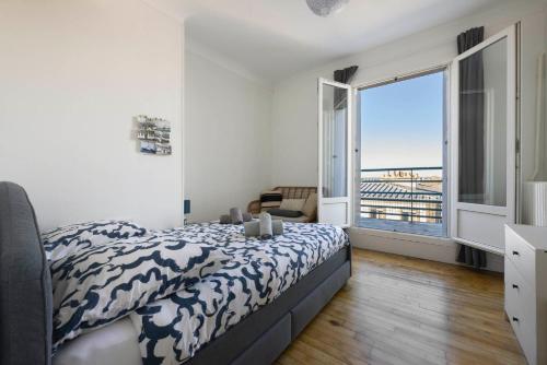 une chambre avec un lit et une grande fenêtre dans l'établissement Vue mer / Jaurès-Centre-Ville / Appart Lumineux, à Brest