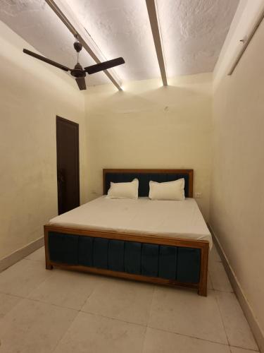 a bed in a room with a ceiling fan at Tirupati Homestay in Varanasi