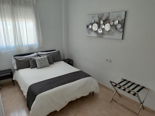 a bedroom with a bed and a picture on the wall at Ventana a Granada de Marijose in Las Gabias