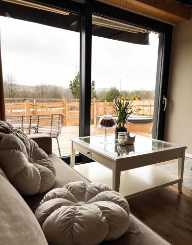 a living room with a couch and a table with a view at Domki Fajnie.Tu in Łączna