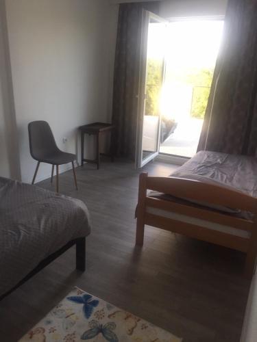 a bedroom with a bed and a chair and a window at Relax House in Banja Luka