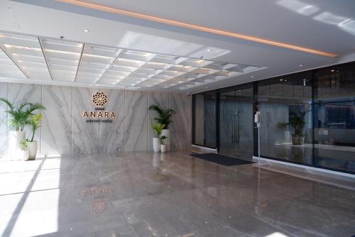 a lobby with aania sign on the wall of a building at Grand Anara Airport Hotel in Tangerang