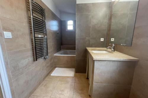 a bathroom with a sink and a bath tub at Maison au cœur des Corbières in Saint-Laurent-de-la-Cabrerisse