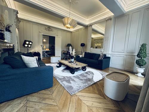 a living room with a blue couch and a table at 41 Maufoux By Bruno Colin - Parenthèse Élégante à Beaune in Beaune