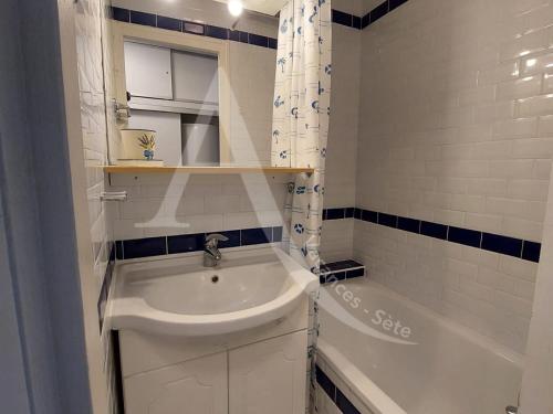 La salle de bains blanche est pourvue d'un lavabo et d'une baignoire. dans l'établissement 54 M², DOUBLE TERRASSE, ASCENSEUR, PARKING, à Sète