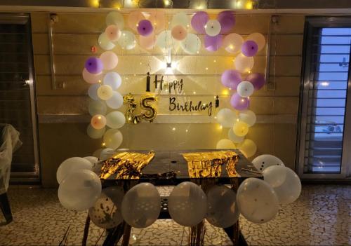 a table with balloons and a sign that reads happy birthday at Riddhi Sea View Bungalow Ganpatipule for Family in Ratnagiri