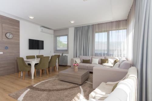 a living room with a couch and a dining room at pazaric residence in Doljani