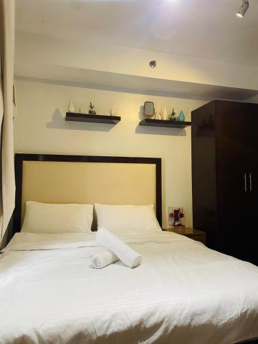 a bed with a white towel on top of it at Cozy 1 Bedroom Condo Unit in Manila