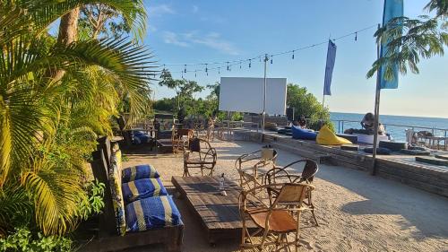 a group of chairs and tables on a beach at Fumba Town Tausi Apartments in Zanzibar City