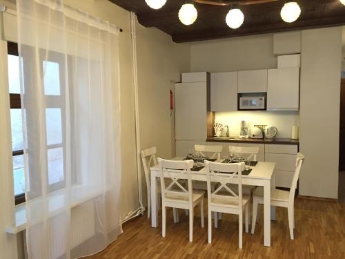 a dining room with a white table and chairs at Mohri Old Town Apartments in Pärnu