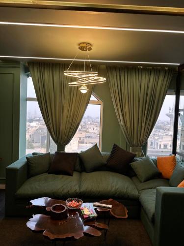 a living room with a couch and a large window at Luxury Elite Apartment with Exclusive Views in Lahore
