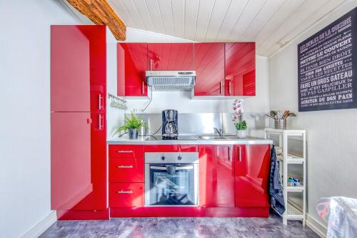 a kitchen with red cabinets and a red refrigerator at Sur La Route Des Vins - Libourne in Libourne