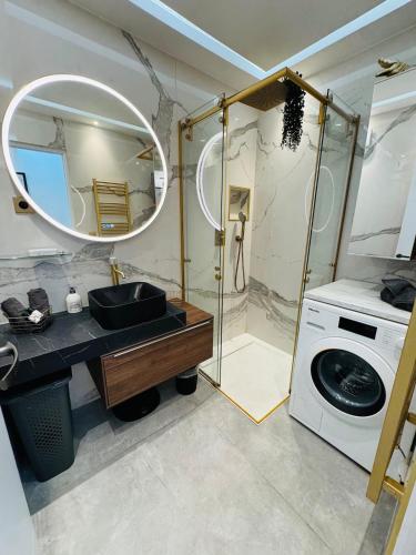une salle de bain avec un lavabo et une machine à laver dans l'établissement Beautiful Cannes Beachfront Apartment 4 pers, à Cannes