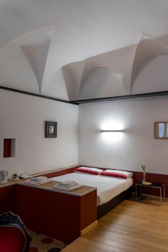 a bedroom with a bed and a table with red pillows at Parma, Antico Studio dietro al Battistero in Parma