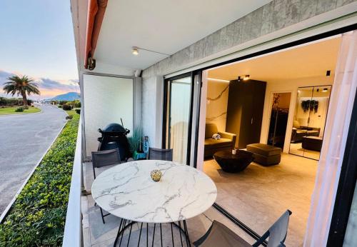 un patio avec une table et des chaises blanches sur un balcon dans l'établissement Beautiful Cannes Beachfront Apartment 4 pers, à Cannes