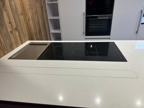 a white counter top with a sink in a kitchen at Le Randonneur charmful chalet near Zermatt 6 to 12p in Täsch