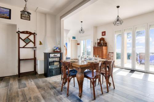 une salle à manger avec une table et des chaises en bois dans l'établissement Face à l'océan, belle maison spacieuse pour 6, à Préfailles