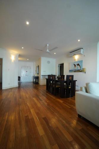 a living room with a white couch and a wooden floor at Colombo City 3 Bedroom Apartment with Pool Gym & Workdesk in Colombo