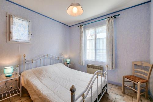 une chambre avec un lit, une chaise et une fenêtre dans l'établissement La Couarde sur Mer, maison pour 6 personnes, à La Couarde-sur-Mer