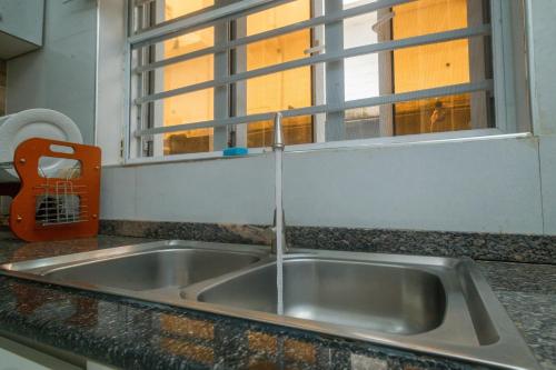 a kitchen sink with water coming out of a window at Monic luxury homes and Apartment in Lagos