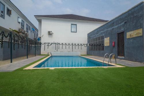a swimming pool in a yard next to a building at Monic luxury homes and Apartment in Lagos