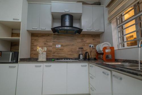 a kitchen with white cabinets and a stove at Monic luxury homes and Apartment in Lagos