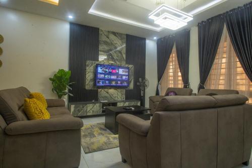a living room with couches and a flat screen tv at Monic luxury homes and Apartment in Lagos