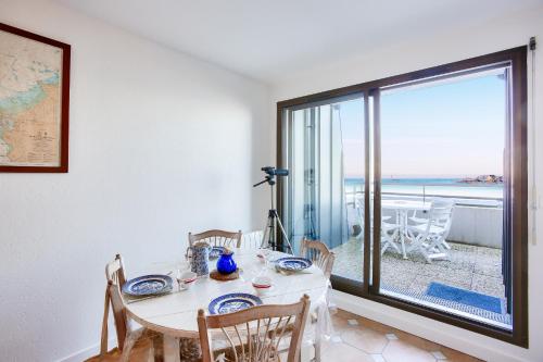 une salle à manger avec une table et une vue sur l'océan dans l'établissement Appartement avec balcon vue mer, pour 4 personnes, à Dinard