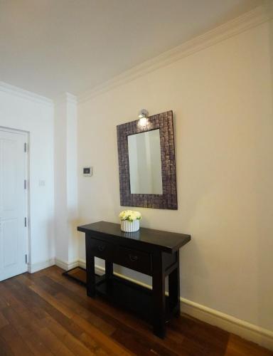 a room with a table with a mirror on the wall at Colombo City 3 Bedroom Apartment with Pool Gym & Workdesk in Colombo