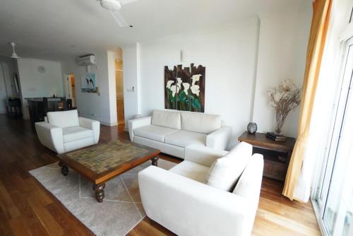 a living room with white couches and a coffee table at Colombo City 3 Bedroom Apartment with Pool Gym & Workdesk in Colombo