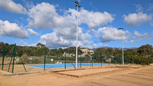 - un court de tennis avec des lumières sur le côté dans l'établissement Appt T2 plus cabine les pieds dans l'eau, à Pianottoli-Caldarello