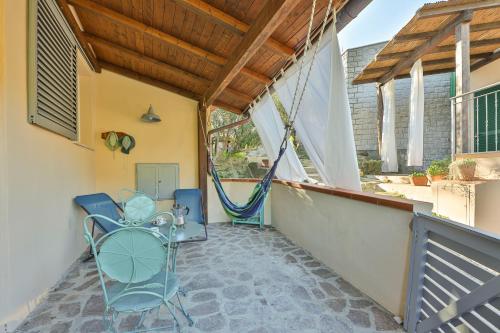 a patio with a hammock and chairs on a porch at Appartamenti del Sole - Goelba in Seccheto