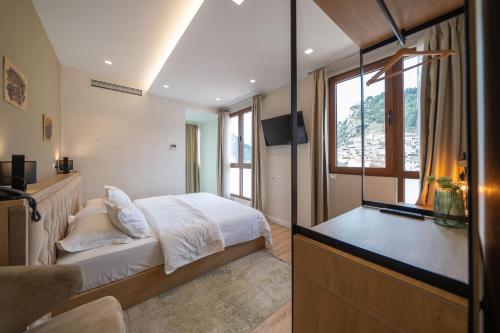 a bedroom with a bed and a window and a television at MERKO HOTEL in Berat