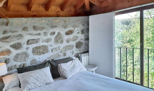 ein Schlafzimmer mit einer Steinmauer und einem Bett in der Unterkunft Charming House in Covelas with Shared Pool in Póvoa de Lanhoso