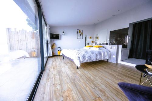 a bedroom with a bed and a large window at La Suite Soleil Romantique & Vue in Istres