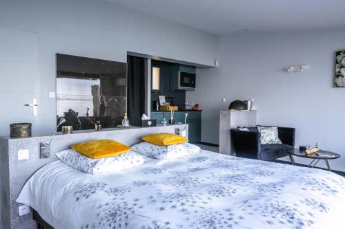 a bedroom with a large white bed with yellow pillows at La Suite Soleil Romantique & Vue in Istres