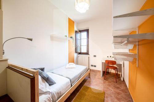 a small room with a bed and a desk at Homiday - Tuscany House - Parcheggio e Giardino Privato in Pisa