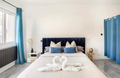 une chambre avec un grand lit avec des rideaux bleus dans l'établissement Septième 7 Sens, à Jarville-la-Malgrange