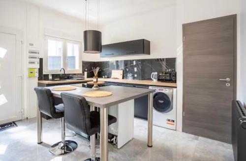 une cuisine avec une table et quelques chaises dans l'établissement Septième 7 Sens, à Jarville-la-Malgrange