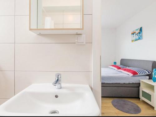 a bathroom with a sink and a bed at Apartments Stella in Krk
