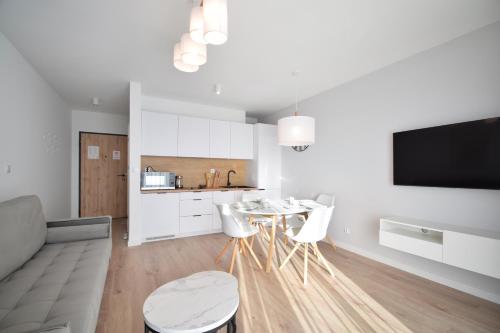 a kitchen and a living room with a table and chairs at RentPlanet - Apartament Marina in Rogowo