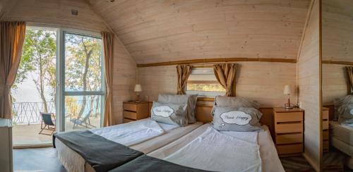 a bedroom with a bed in a room with a window at Къщички Синьо лято, Черноморец - Варна - Blue Summer Houses Varna in Varna City