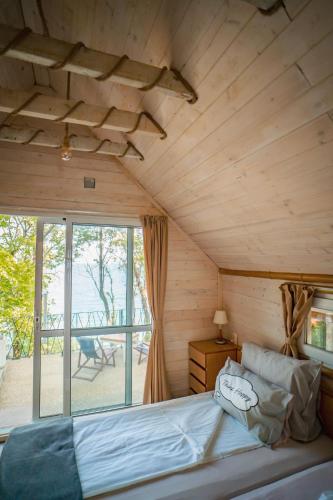 a bed in a room with a wooden ceiling at Къщички Синьо лято, Черноморец - Варна - Blue Summer Houses Varna in Varna City