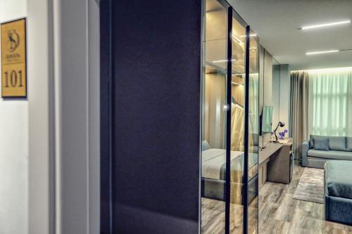 a room with a bedroom with a bed and a mirror at Hotel Dirista in Shkodër