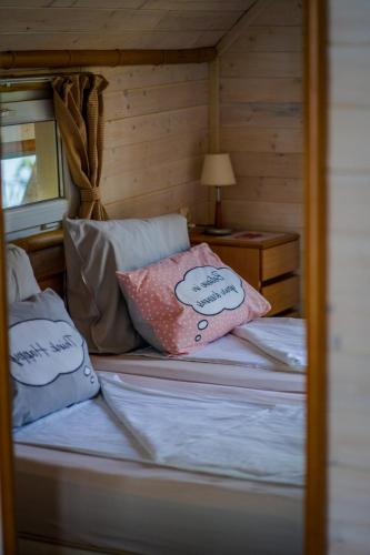a bed with two pillows on it in a room at Къщички Синьо лято, Черноморец - Варна - Blue Summer Houses Varna in Varna City