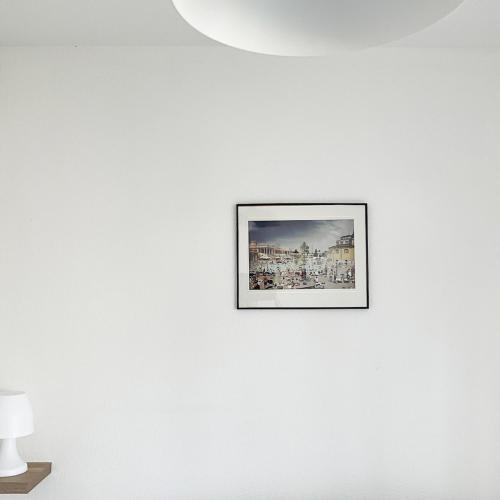 a picture hanging on a white wall in a room at Appartement cosy avec wifi en bord de mer in Poggio-Mezzana