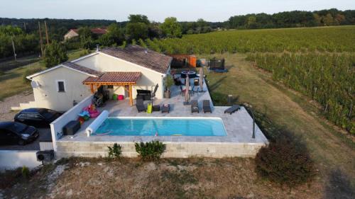 - une vue aérienne sur une maison avec une piscine dans un champ dans l'établissement C'est la vie là ! Jolie maison avec piscine, à Saint-Astier