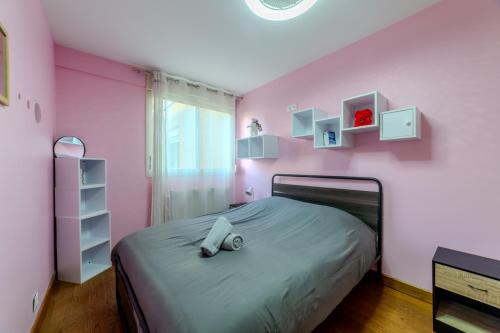 - une chambre avec un lit dans une chambre rose dans l'établissement T5 Chaleureux - Jardin Privatif & 2 Parking, à Villeurbanne