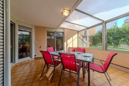 une salle à manger avec une table et des chaises rouges dans l'établissement T5 Chaleureux - Jardin Privatif & 2 Parking, à Villeurbanne