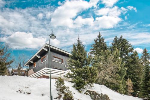 a house on a snowy hill with a street light at La Perchette - Joli chalet classé 3 étoiles in Chamrousse